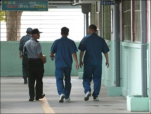 한 교도관이 재소자들과 걸어가면서 얘기를 나누고 있다.(사진은 기사 내용과 직접 관련 없습니다.)